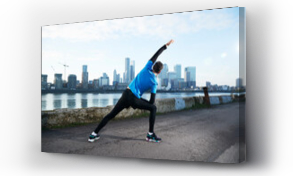 Wizualizacja Obrazu : #430406108 UK, London, Jogger stretching with downtown skyline in background