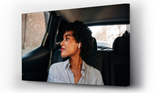 Wizualizacja Obrazu : #433677205 Carefree young African American female with TWS earbuds listening to music in modern automobile looking out the windows