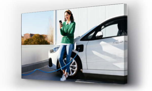 Wizualizacja Obrazu : #439562792 Woman using smartphone near electric car on charging station