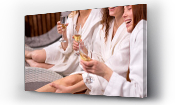 Wizualizacja Obrazu : #439706152 Elegant charming women holding glass on champagne in hand enjoying great time in spa resort hotel, close-up photo of hands, cropped ladies in bathrobes
