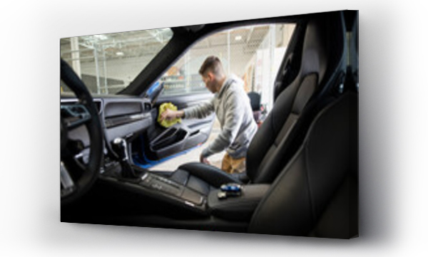 Wizualizacja Obrazu : #441033834 Mężczyzna pracujący przy detailingu wnętrza samochodu sportowego w warsztacie samochodowym