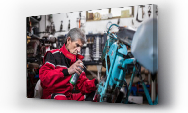 Wizualizacja Obrazu : #442948991 Starszy mechanik natryskuje olej na części motocykla w warsztacie