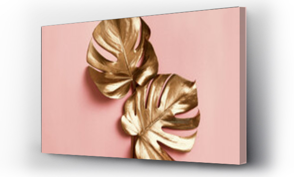 Wizualizacja Obrazu : #447672755 Natural luxury still life. Golden monstera leaves on pastel pink background. Minimal fine art creative concept. Flat lay design. Trendy exotic tropical botany wallpaper.