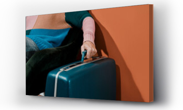 Wizualizacja Obrazu : #486645800 young man grabs the handle of a blue retro suitcase