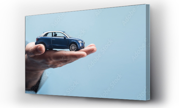 Wizualizacja Obrazu : #487205644 Mans hand holding a car on a blue background