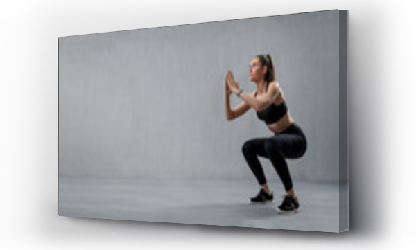 Wizualizacja Obrazu : #507423344 Sports woman in fashion black sport clothes squatting doing sit-ups in gym, over gray background