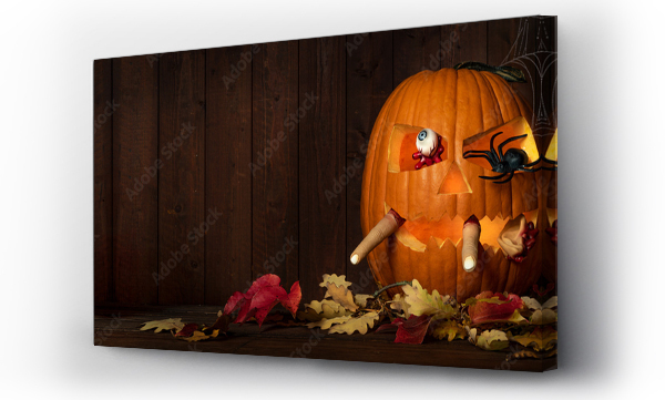 Wizualizacja Obrazu : #536370382 Scary Halloween celebration holiday party card background banner - Spooky carved glowing pumpkins with spider and human bloody body parts ( eye, finger and ear) in his mouth on wooden table and wall