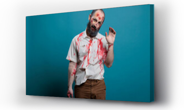 Wizualizacja Obrazu : #539581838 Dangerous zombie waving hello at camera, doing salute gesture over blue background. Creepy apocalyptic evil monster with bloody scars and wounds, brain eating aggressive corpse.
