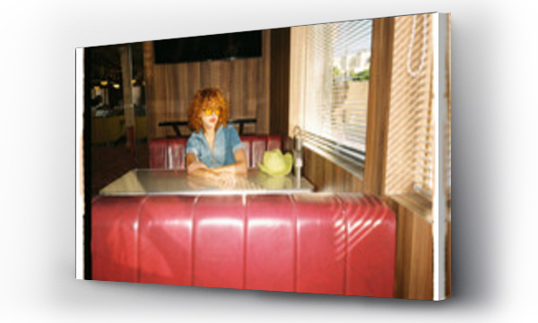 Wizualizacja Obrazu : #546714428 woman sitting on a red sofa in a retro restaurant