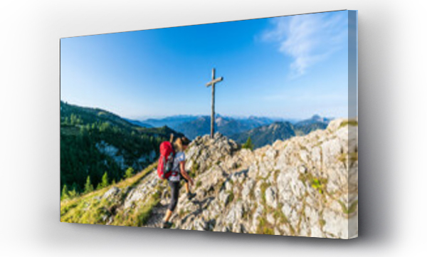Wizualizacja Obrazu : #556629631 Germany, Bavaria, Female hiker walking past summit cross on Taubenstein mountain