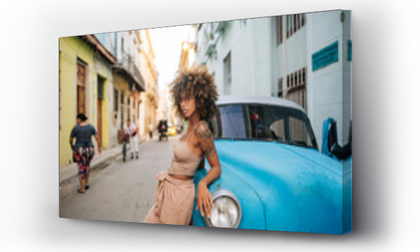 Wizualizacja Obrazu : #584850245 Confident Cuban female leaning on blue car