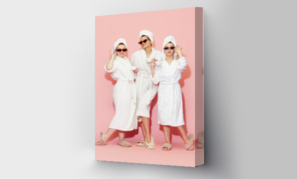 Wizualizacja Obrazu : #589268743 Stylish tree young girls in bathrobes and towels, drinking coffee against pink studio background. After spa and massage. Concept of youth, face care, beauty, friendship, party, relaxation