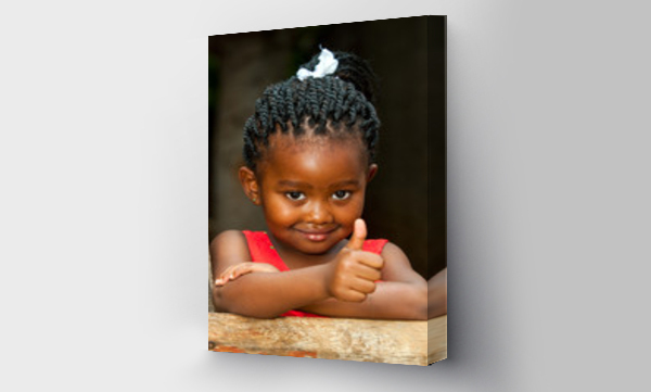 Mała afrykańska dziewczynka przy drewnianym płocie z kciukami w górę.