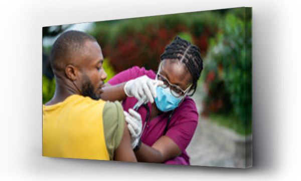 Wizualizacja Obrazu : #627357902 image of young african nurse in face mask, injecting young black guy outside- home care service in africa