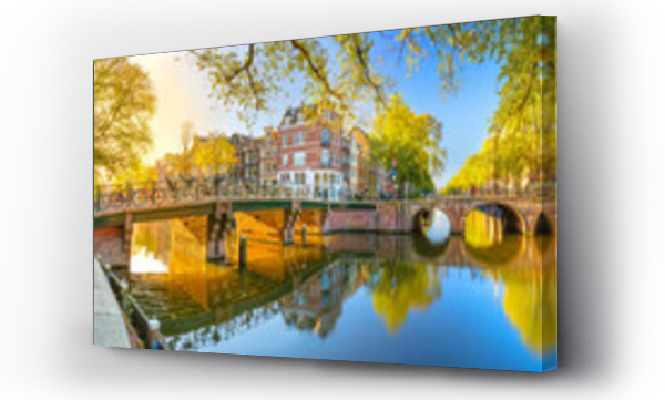 Wizualizacja Obrazu : #635318695 Panoramic view of Amsterdam in the morning sun. Traditional old houses, bridges and mirror water with reflection. Beautiful morning in Amsterdam.