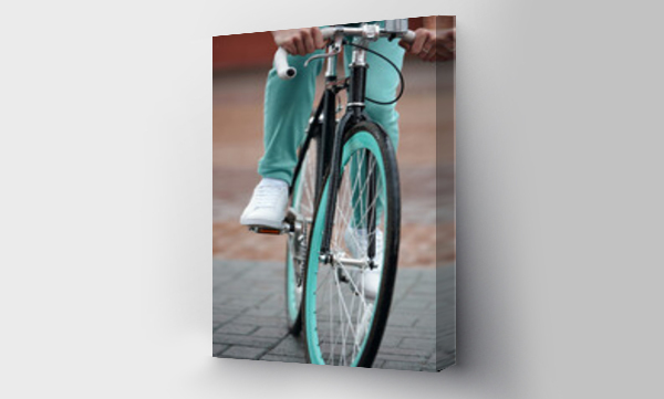 Wizualizacja Obrazu : #641500339 Unrecognizable man in blue pants and white sneakers riding a bike with blue rims along the sidewalk  