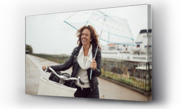 Wizualizacja Obrazu : #641752354 Smiling young woman holding an umbrella while riding her bike around town on a rainy day