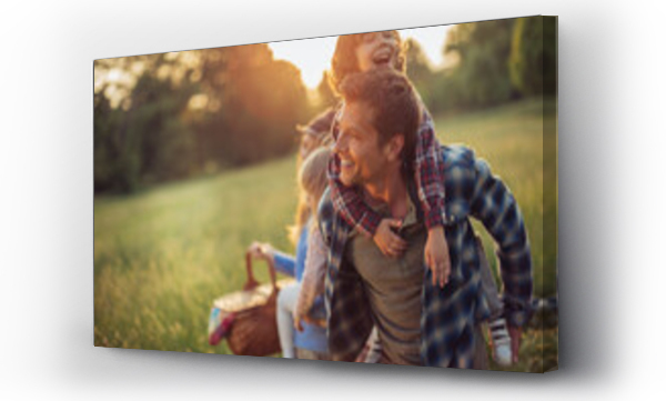 Wizualizacja Obrazu : #641921987 Young caucasian family having a picnic on a grassy field in nature