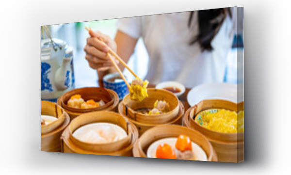 Wizualizacja Obrazu : #651770251 Young woman traveler eating traditional Chinese Dim Sum at restaurant