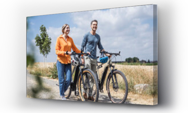 Wizualizacja Obrazu : #656977582 Couple wheeling with bicycles on road near field