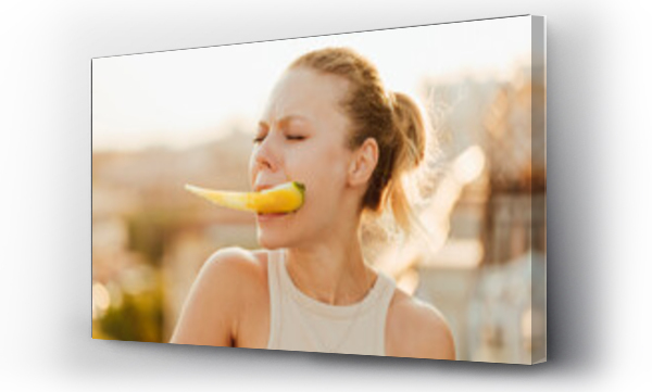 Wizualizacja Obrazu : #658228783 Woman holding piece of yellow watermelon in her teeth