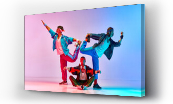 Wizualizacja Obrazu : #664861001 Funny, athletic young men in vintage sportswear training, doing stretching exercises over gradient pink blue background in neon light. Concept of sportive and active lifestyle, humor, retro style. Ad