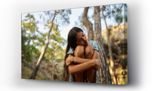 Wizualizacja Obrazu : #666440891 Lonely teenage girl with eyes closed hugging knees in forest