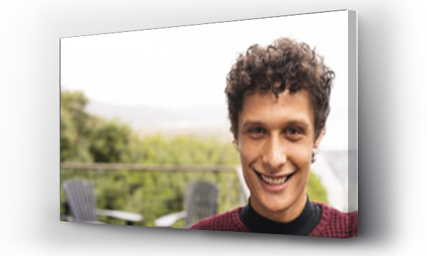 Wizualizacja Obrazu : #668556537 Portrait of happy biracial man with curly hair at balcony over forest view, copy space