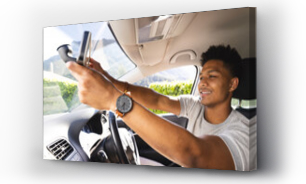 Wizualizacja Obrazu : #671469100 Happy african american man adjusting rearview mirror in car on sunny day