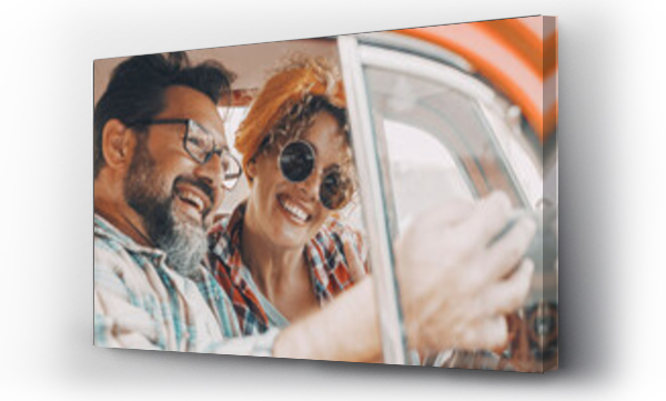 Wizualizacja Obrazu : #676436397 Happy couple having fun inside a car during travel adventure. Cheerful man and woman smiling and laughing a lot together. People enjoying vehicle trip in friendship and relationship. Concept of drive