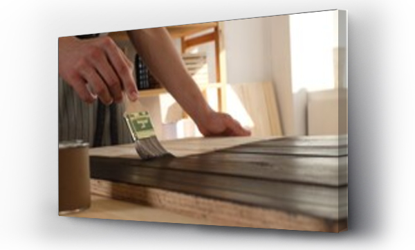 Wizualizacja Obrazu : #679441748 Man with brush applying wood stain onto wooden surface indoors, closeup
