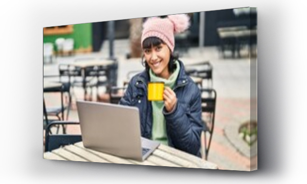 Wizualizacja Obrazu : #681020607 Young beautiful hispanic woman using laptop drinking coffee sitting on table at coffee shop terrace