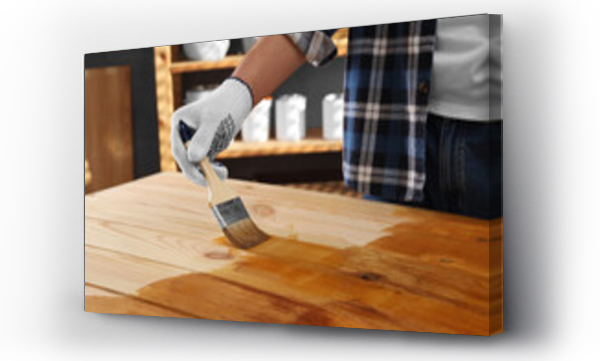 Wizualizacja Obrazu : #682594772 Man with brush applying wood stain onto wooden surface indoors, closeup