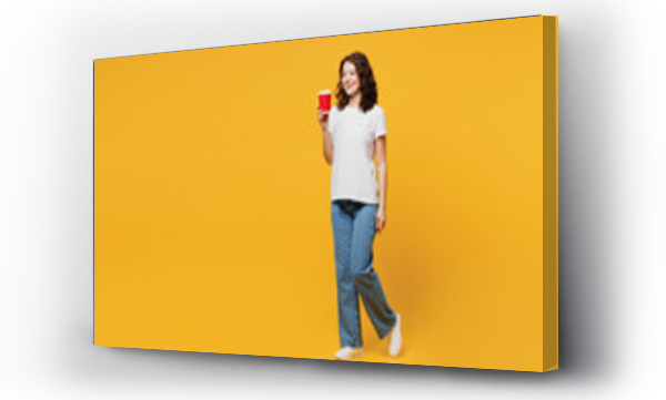 Wizualizacja Obrazu : #686035296 Full body young woman wear white blank t-shirt casual clothes hold takeaway delivery craft paper brown cup coffee to go isolated on plain yellow orange background studio portrait. Lifestyle concept.