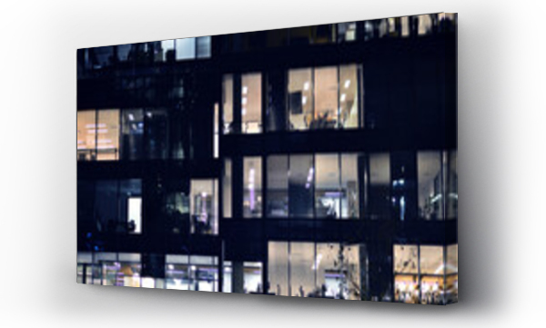 Wizualizacja Obrazu : #689865642 Fragment of the glass facade of a modern corporate building at night. Modern glass office  in city. 