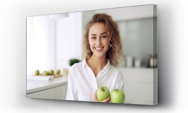 Wizualizacja Obrazu : #690914657 Young attractive joyful woman with green apple smile on kitchen background. Nutritionist, vegetarianism, healthy eating. The benefits of fruit for breakfast.