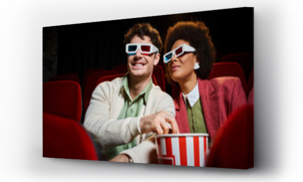 Wizualizacja Obrazu : #692662689 cheerful young multiethnic couple with retro 3d glasses watching movie and eating popcorn on date