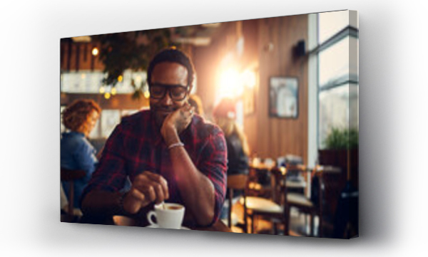 Wizualizacja Obrazu : #693650114 Young man enjoying coffee at a cafe