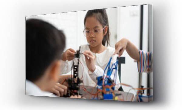 Wizualizacja Obrazu : #693995759 Happy Asia kid girl studying with electric robot and friend in classroom	