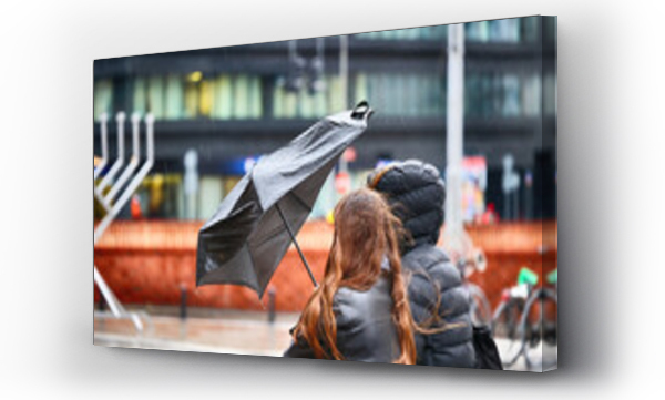 Wizualizacja Obrazu : #697064359 Ludzie pod parasolem w czasie deszczu i wiatru. 