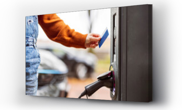 Wizualizacja Obrazu : #698984402 Woman paying with credit card at electric car charging station