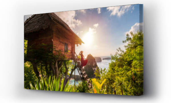 Wizualizacja Obrazu : #705442147 Young woman traveler enjoying and looking beautiful sunrise at the tree house in Nusa Penida island Bali, Indonesia