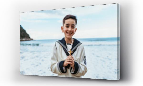 Wizualizacja Obrazu : #761435108 A beaming boy holding a crucifix stands by the sea, dressed in his First Communion sailor suit, embodying joy and faith
