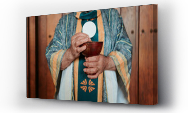 Wizualizacja Obrazu : #761435335 Anonymous priest elevates the Eucharistic host above a chalice, a central ritual in the celebration of the Christian Communion service