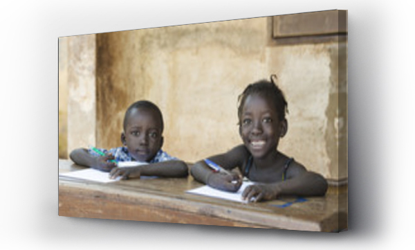 Urocze małe dzieci uczące się z długopisami na papierze w Mali, Afryka
