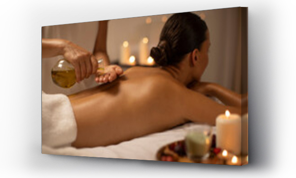 Wizualizacja Obrazu : #906837437 Massage therapist pouring oil on lady back at luxury spa decorated with candles, body care concept. Woman enjoying relaxing massage with aromatherapy