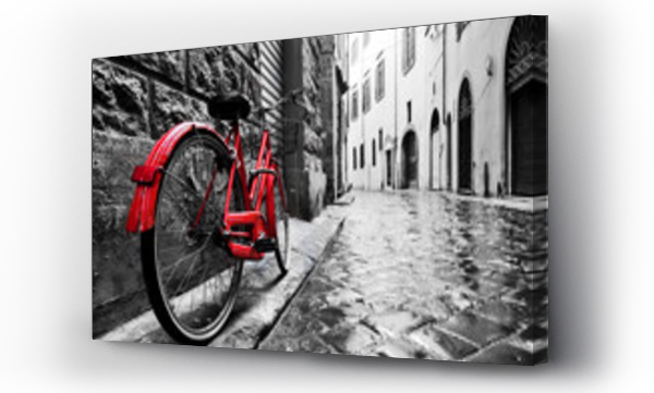 Retro vintage czerwony rower na brukowanej ulicy w starym mieście. Kolor w czerni i bieli